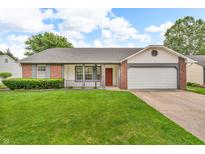 Charming single-Gathering home featuring a manicured lawn, red front door, and attached two-car garage at 6853 Kellum Dr, Indianapolis, IN 46221