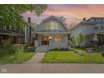 Charming two-story home featuring a well-maintained lawn and inviting front porch with craftsman details at 909 N Parker Ave, Indianapolis, IN 46201