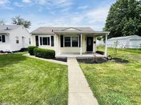 Charming single-story home featuring a well-maintained lawn and inviting entryway at 128 E 36Th St, Anderson, IN 46013