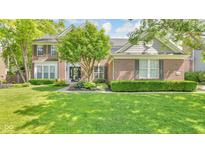 Traditional brick home featuring manicured lawn, mature landscaping, and charming curb appeal at 13304 Landwood Dr, Fishers, IN 46037