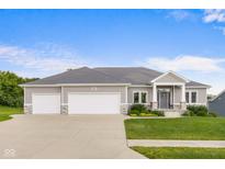 Charming single-Gathering home featuring a three-car garage and a beautifully landscaped front yard at 1497 Maple Ridge Ct, Columbus, IN 47201