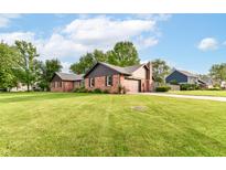 Charming brick home with a well-manicured lawn and mature trees on a sunny day at 206 Banbury Rd, Noblesville, IN 46062