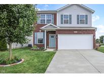 Charming two-story home with brick facade, blue shutters, landscaped yard, and a two-car garage at 2101 Shadow Fox Dr, Columbus, IN 47201