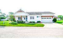 Charming single-story home featuring a manicured lawn, attached two-car garage, and inviting front porch at 4305 W Coyote Run Ct, Muncie, IN 47304