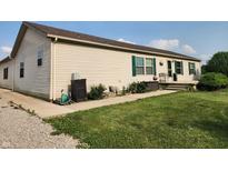 Charming single-story home featuring green shutters, lovely landscaping, and a cozy front porch at 4815 N 500 W, Columbus, IN 47201