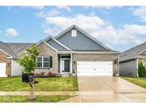Charming single-Gathering home with a gray brick facade, blue siding and a well-manicured lawn and a two car garage at 5439 Maywood Dr, Whitestown, IN 46075