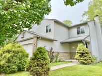 Charming two-story home with manicured front yard and attached two car garage at 5826 Buck Rill Dr, Indianapolis, IN 46237