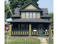 Charming two-story home featuring a covered front porch and a well-maintained yard at 624 N Rural St, Indianapolis, IN 46201