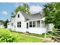 Charming home featuring classic architecture, landscaped greenery, and a welcoming enclosed porch at 706 University Blvd, Anderson, IN 46012