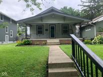 Charming craftsman home featuring a covered porch, walkway, and neatly maintained lawn with garden bed accents at 730 N Riley Ave, Indianapolis, IN 46201