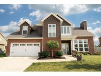 Charming two-story home with a brick and brown wood exterior and a manicured front lawn at 750 Trillium St, Lebanon, IN 46052