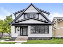 Charming two-story home with white and black accents, landscaped yard, and inviting curb appeal at 911 Eastern Ave, Indianapolis, IN 46201