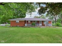 Charming brick home with a covered front porch and a lush green lawn at 9974 N 850 W, Fairland, IN 46126