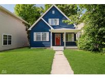 Charming two-story home with blue siding, white trim, and a well-manicured lawn at 1038 W 33Rd St, Indianapolis, IN 46208