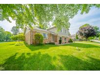 Inviting two-story home showcasing a well-manicured front yard and classic brick accents at 1111 Pendle Hill Ave, Pendleton, IN 46064
