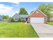Charming home featuring a well-manicured lawn, brick accents, and attached two-car garage at 11218 Baycreek Dr, Indianapolis, IN 46236