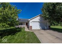 Charming single-story home with a well-manicured lawn and attached two-car garage at 11830 Sand Creek Blvd, Fishers, IN 46037