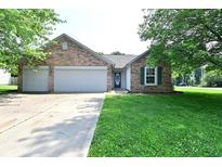 Charming brick home featuring an attached two-car garage and a well-manicured lawn at 1411 Mimosa Ct, Greenfield, IN 46140