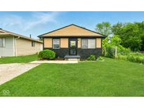 Charming single Gathering home with manicured lawn, neutral paint scheme and welcome wreath on the front door at 1513 S Rural St, Indianapolis, IN 46203