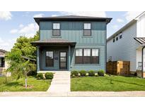 Charming two-story home with blue siding, a well-manicured lawn, and a welcoming front porch at 1717 Carrollton Ave, Indianapolis, IN 46202