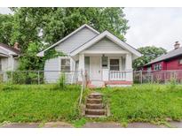 Charming home featuring a covered front porch and a well-manicured front yard at 1938 N Dearborn St, Indianapolis, IN 46218