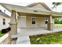 Inviting front porch with sturdy brick columns and fresh concrete, creating a welcoming entrance to this charming home at 2026 Spruce St, Indianapolis, IN 46203