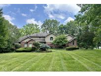 Beautifully landscaped yard and traditional brick home with a manicured lawn at 2213 E Canterbury Ct, Martinsville, IN 46151