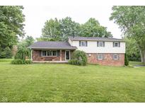 Charming split-level home featuring a brick facade, light siding, mature trees, and a well-manicured lawn at 2457 N Centerline Rd, Franklin, IN 46131