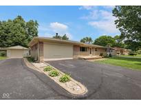 Charming single-story home with brick and stone details, attached garage, and well-maintained landscaping at 406 W Mcgregor Rd, Indianapolis, IN 46217