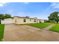 Charming single-story home with a well-maintained lawn and long concrete driveway at 4697 W Ridge Dr, Columbus, IN 47203