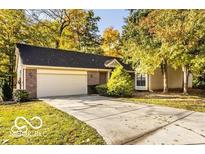 Charming single-story home featuring a brick facade, an attached two-car garage, and a concrete driveway at 5303 Windridge Dr # 172, Indianapolis, IN 46226