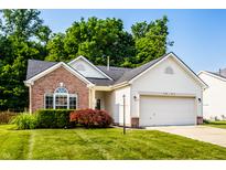 Charming home with brick accents, a two-car garage, and a well-maintained lawn on a sunny day at 5883 Hollow Oak, Carmel, IN 46033