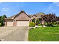 Charming brick home with a manicured front yard, mature landscaping, and a spacious three-car garage at 648 Shakespeare Dr, Avon, IN 46123
