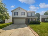 Charming two-story home featuring a two-car garage and a well-maintained front yard with blue sky at 8437 Crosser Dr, Indianapolis, IN 46237