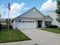 Charming single-Gathering home featuring a two-car garage, well-manicured lawn, and flag at 878 Sommersweet Run, Greenwood, IN 46143