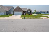 Charming single-story brick home with a well-manicured lawn and two car garage in a suburban neighborhood at 9001 Fitzgerald Dr, Indianapolis, IN 46239