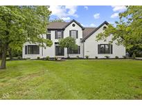 Charming two-story home features a white brick exterior and a lush, green lawn at 9148 Oak Knoll Ln, Fishers, IN 46037