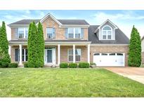 Charming two-story brick home with a manicured lawn and inviting front porch at 1143 Hampton Dr, Greenwood, IN 46143