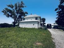 Charming two-story farmhouse featuring durable siding, a large yard, and a gravel driveway at 1170 E 400 S, Lebanon, IN 46052