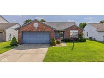 Charming single-story brick home featuring an attached garage, well-manicured lawn, and welcoming front entrance at 1547 Millridge Dr, Greenwood, IN 46143