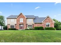 Charming two-story home with a brick facade, manicured lawn, and beautiful landscaping at 1826 Spruce Dr, Carmel, IN 46033