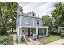 Charming two-story blue home featuring a spacious covered front porch with elegant white columns at 250 N Home Ave, Franklin, IN 46131