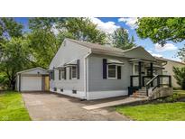 Charming home featuring light gray siding, a detached garage, and manicured landscaping at 311 S 6Th Ave, Beech Grove, IN 46107