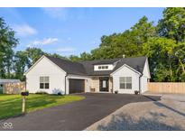 Charming home featuring modern farmhouse style, a black asphalt driveway, and a lush green lawn at 3365 Riverside Dr, Columbus, IN 47203