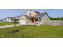 Charming two-story home with a well-maintained lawn and a cozy front porch featuring seasonal decorations at 4605 Clairmont Dr, Columbus, IN 47203