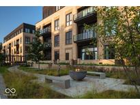 Modern apartment building with balconies, courtyard with benches, and landscaping at 855 N East N St # 104-B, Indianapolis, IN 46202