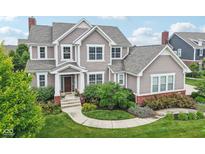 Charming two-story home with landscaped yard, a brick foundation, and neutral toned siding at 10806 Solis Cir, Fishers, IN 46038
