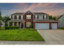 Inviting two-story home boasting a manicured lawn, three-car garage and brick and siding facade with classic shutters at 1343 Turfway Dr, Avon, IN 46123