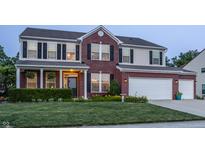 Two-story brick home boasting a well-manicured lawn, attached two-car garage, and classic black shutters at 1343 Turfway Dr, Avon, IN 46123