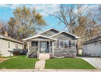 Charming single-story home featuring neutral siding, a cozy front porch, and well-maintained landscaping at 1409 N Chester Ave, Indianapolis, IN 46201